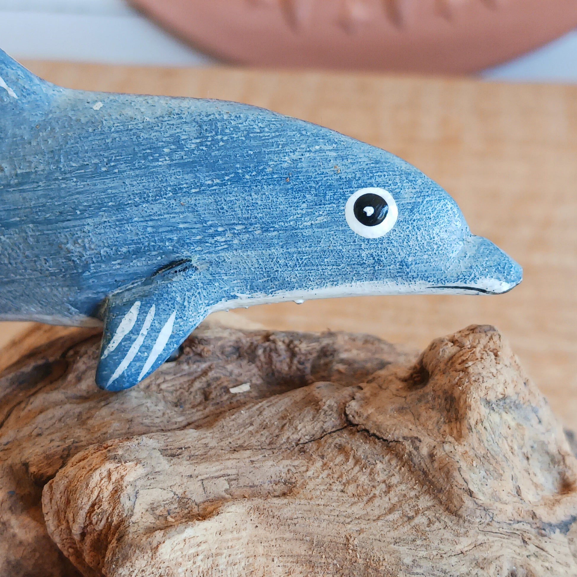 Bring the peaceful beauty of the ocean into your home with this Handcrafted Wooden Blue Dolphin Sculpture. Expertly crafted from sustainably sourced wood, this elegant decorative piece features a beautifully hand-painted blue dolphin gracefully mounted on natural driftwood, creating a striking coastal-inspired display.