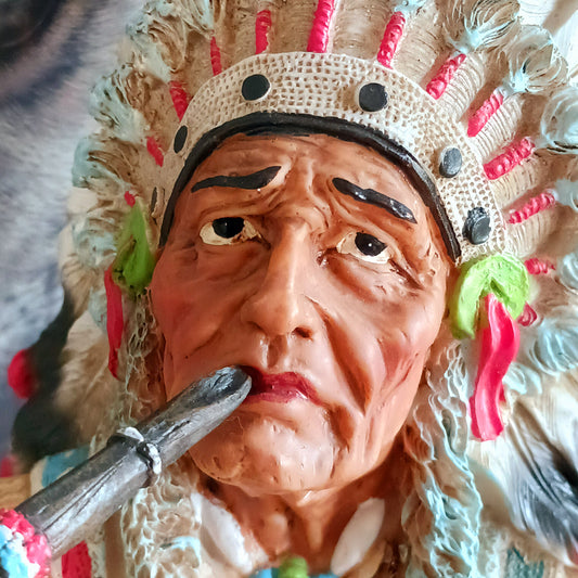 Elevate your space with the serene elegance of this Native American Chief Smoking a Peace Pipe figurine, a captivating symbol of wisdom and cultural harmony. Expertly crafted with intricate detail, this masterpiece depicts a noble chief in traditional tribal attire, smoking a symbolic peace pipe with grace and dignity. From the regal feathered headdress to the delicate carving of the pipe, every element reflects the artistry and cultural depth of Native American traditions. 