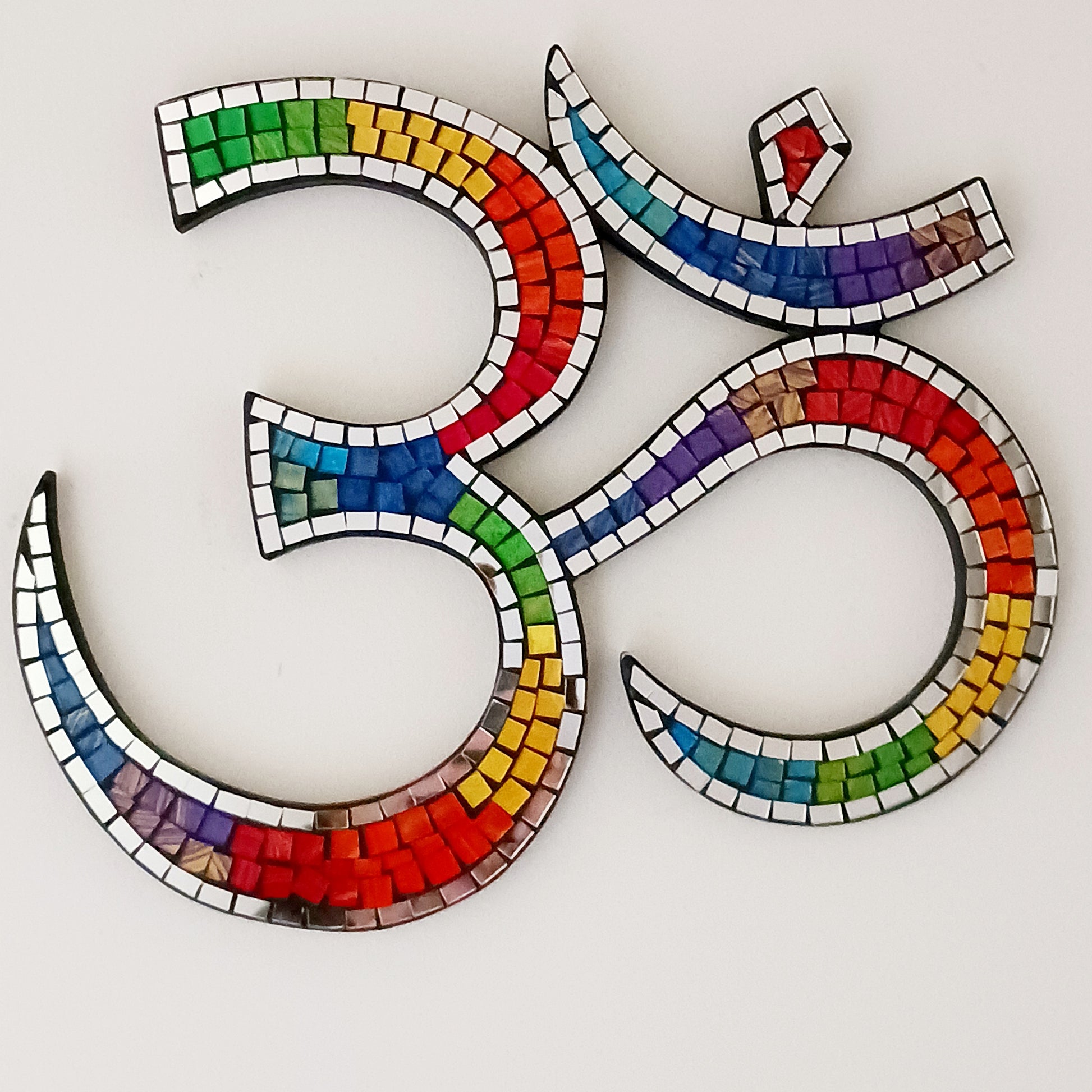 Bring serenity and colour into your sacred space with our&nbsp;Rainbow Mosaic Om Wall Plaque. This stunning piece features a vibrant rainbow design representing the powerful Om symbol — a timeless emblem of inner peace, spiritual connection, and mindfulness. Perfect for meditation rooms, yoga studios, or as a thoughtful gift, this plaque adds both beauty and positive energy to any home décor.