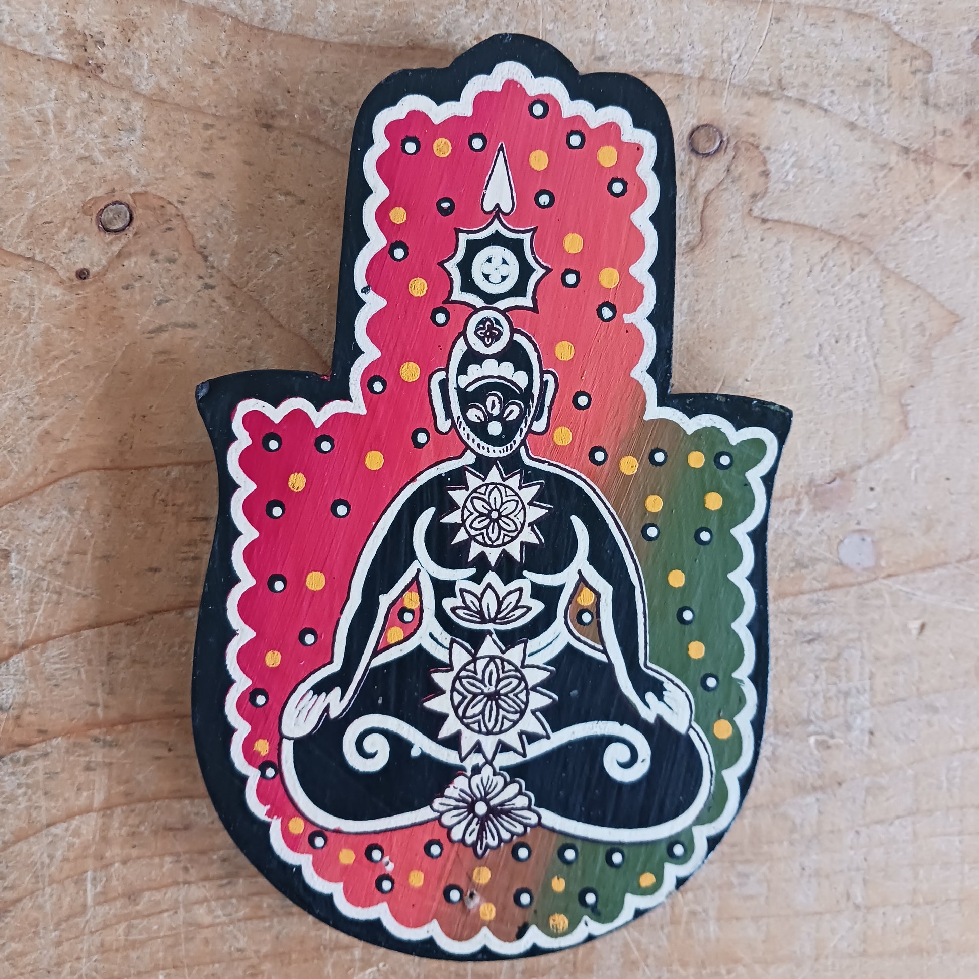 Hold an incense stick securely with this chakra hamsa hand. It has a black base and contrasting rich red and green tones.&