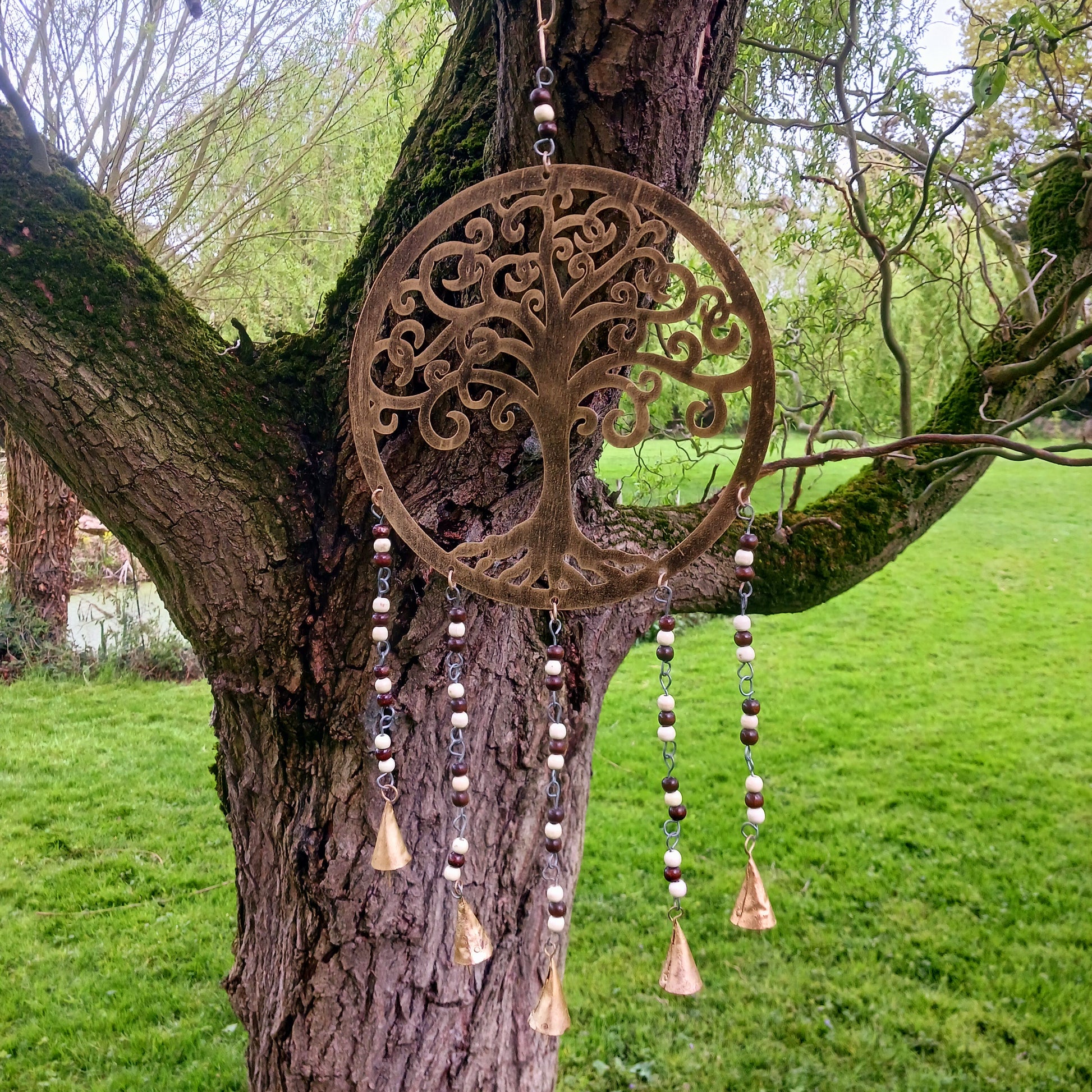 Bring the timeless symbolism of the Tree of Life to your home with this beautiful Tree of Life windchime.  Made in India from quality brass, this 25 cm chime features a beautifully detailed Tree of Life design, adorned with Indian beads. Each branch of the tree is a reminder of growth, connection, and harmony, while the soothing sounds of the bells offer peace to any space.
