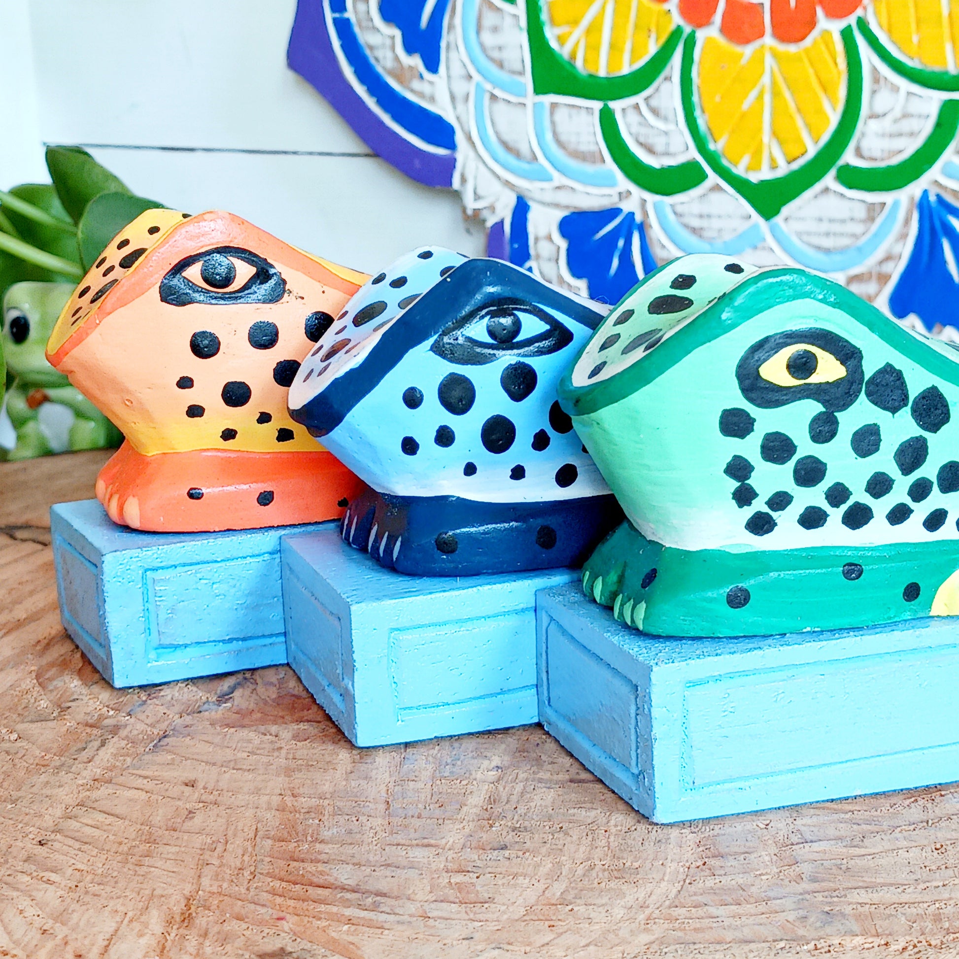 Bring charm and character into your home with this decorative wooden door stopper, featuring a turquoise base and a playful, hand-painted dotty frog design in vibrant blue, green, and orange. Perfect for propping open doors in style, this quirky wedge door stop is both practical and fun.