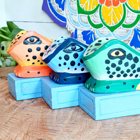 Bring charm and character into your home with this decorative wooden door stopper, featuring a turquoise base and a playful, hand-painted dotty frog design in vibrant blue, green, and orange. Perfect for propping open doors in style, this quirky wedge door stop is both practical and fun.