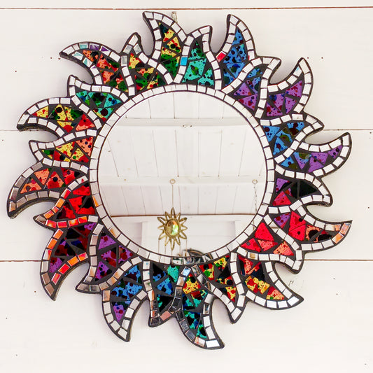 Colorful mosaic mirror with a sun design on a white wooden background