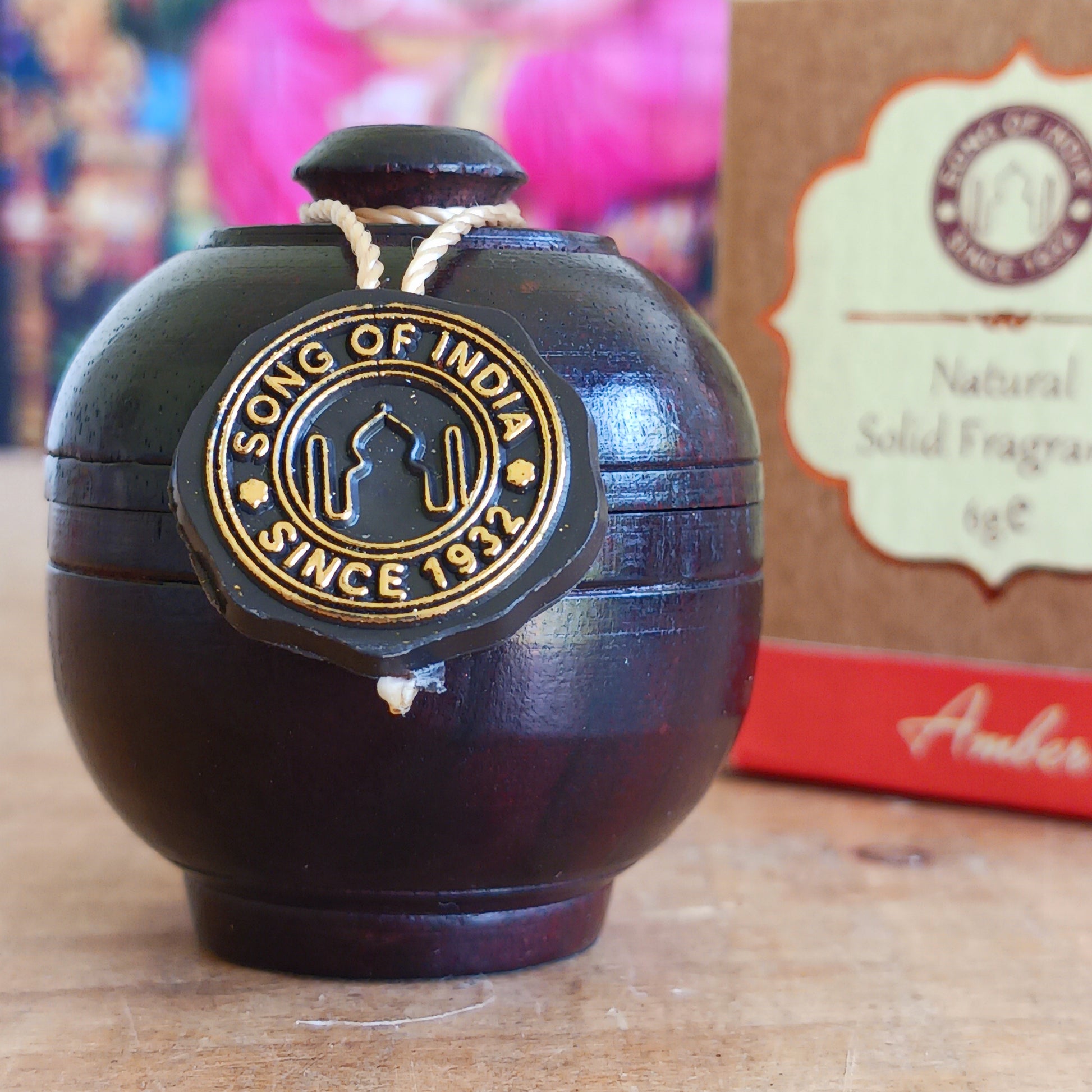 Experience the timeless beauty of jasmine with this luxurious Song of India Amber Fragrance Cream, beautifully housed in a handcrafted rosewood jar. Made by skilled artisans using carefully selected Indian rosewood bark, each container showcases unique natural grain patterns, colours, and veins, making every piece a one-of-a-kind collectible.