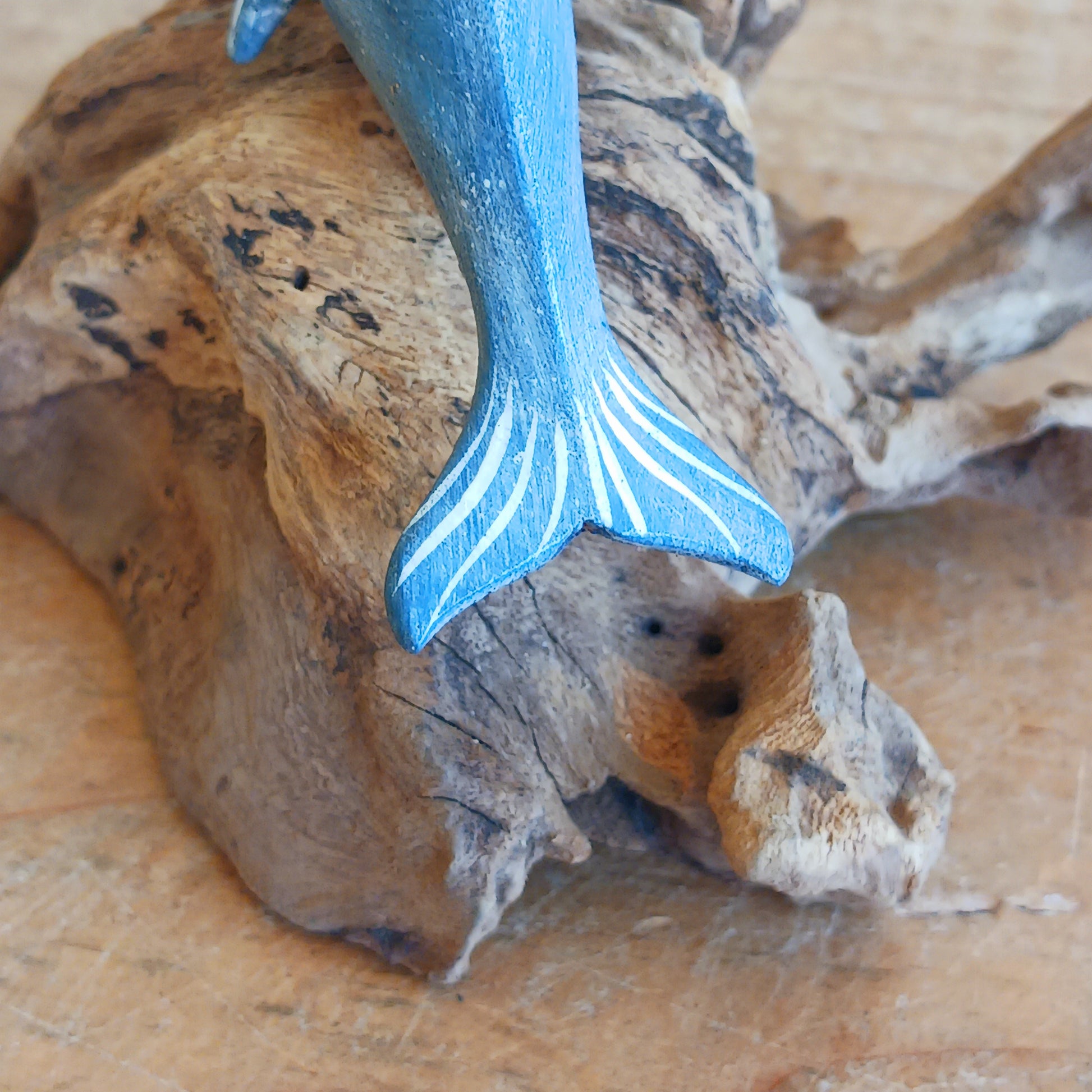 Bring the peaceful beauty of the ocean into your home with this Handcrafted Wooden Blue Dolphin Sculpture. Expertly crafted from sustainably sourced wood, this elegant decorative piece features a beautifully hand-painted blue dolphin gracefully mounted on natural driftwood, creating a striking coastal-inspired display.