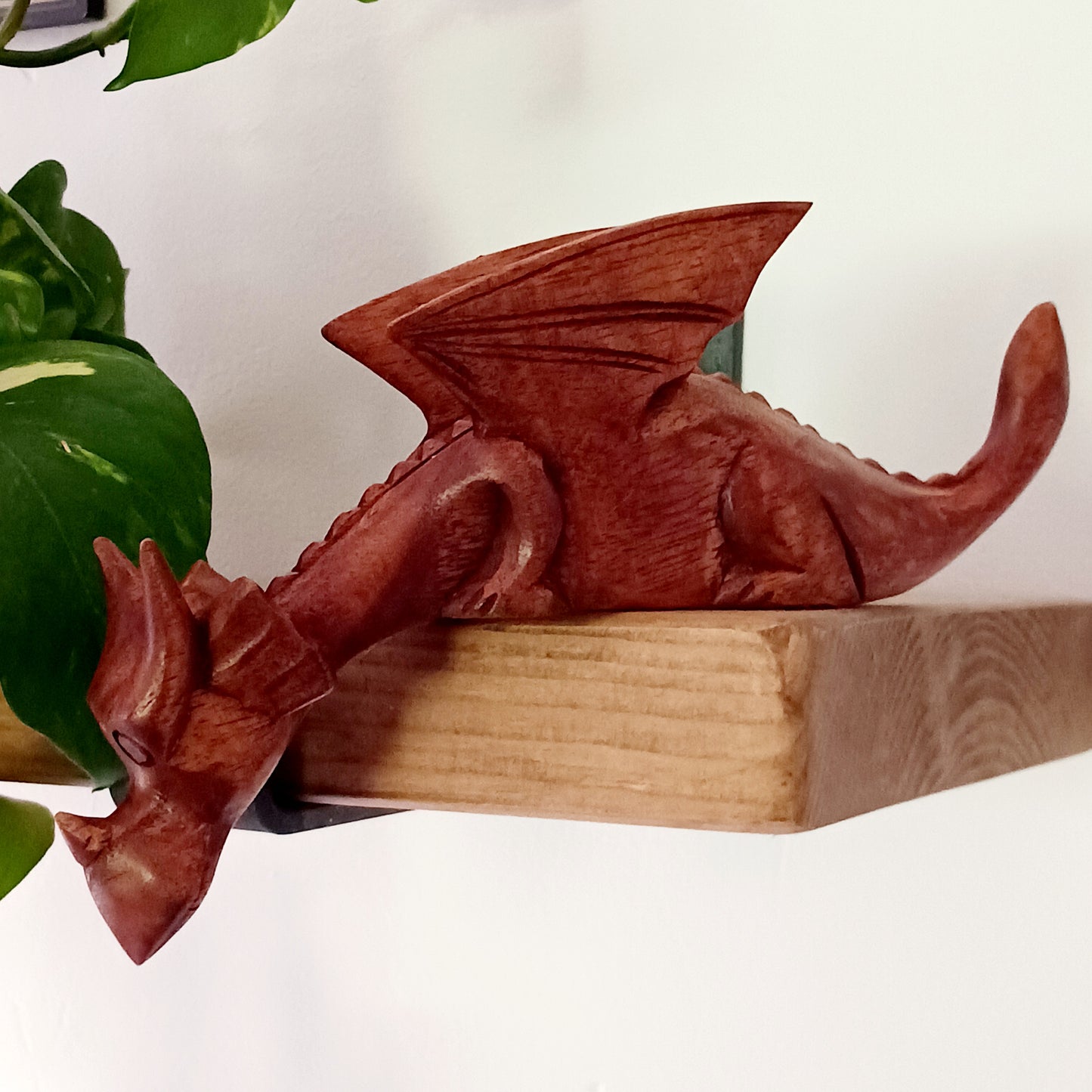 Bring personality and charm into your home with this beautiful hand-carved Shelf Dragon. Expertly crafted with intricate details, this whimsical dragon is designed to perch perfectly on any shelf, mantle, or display space. Its expressive features, artisan carving, and warm natural wood finish make it a captivating accent piece for fantasy lovers, collectors, and anyone who appreciates unique décor.