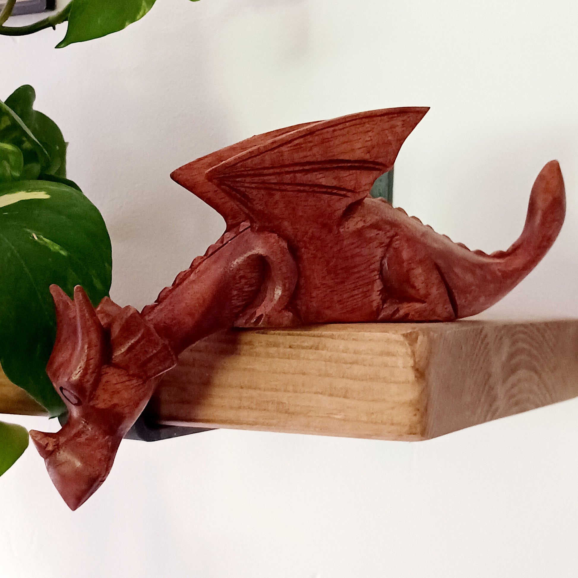 Bring personality and charm into your home with this beautiful hand-carved Shelf Dragon. Expertly crafted with intricate details, this whimsical dragon is designed to perch perfectly on any shelf, mantle, or display space. Its expressive features, artisan carving, and warm natural wood finish make it a captivating accent piece for fantasy lovers, collectors, and anyone who appreciates unique décor.