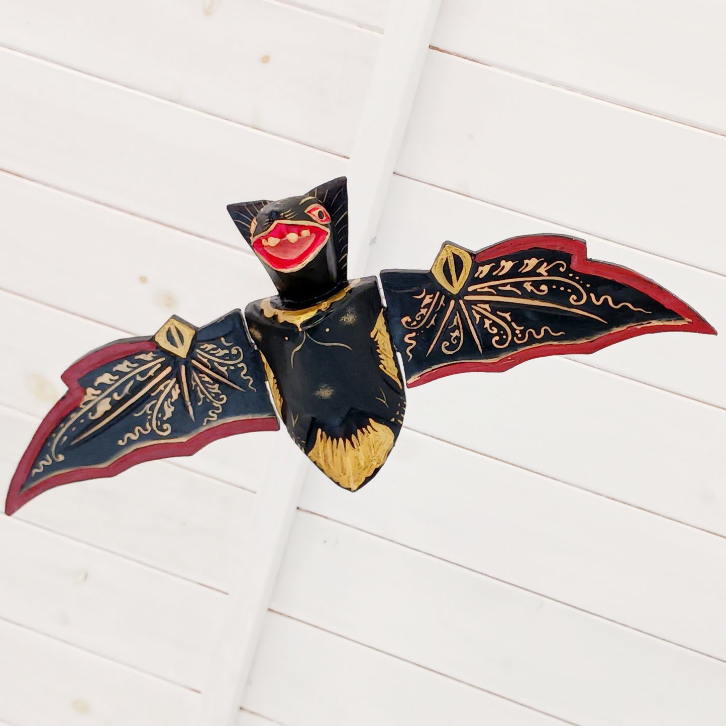Bring a touch of gothic magic into your home with this striking hand-carved wooden flying bat mobile, handmade by skilled artisans in Bali, Indonesia. With its wings dramatically outstretched to approximately 50cm wide, this unusual hanging decoration makes a bold statement suspended from a ceiling, doorway, window or display area.