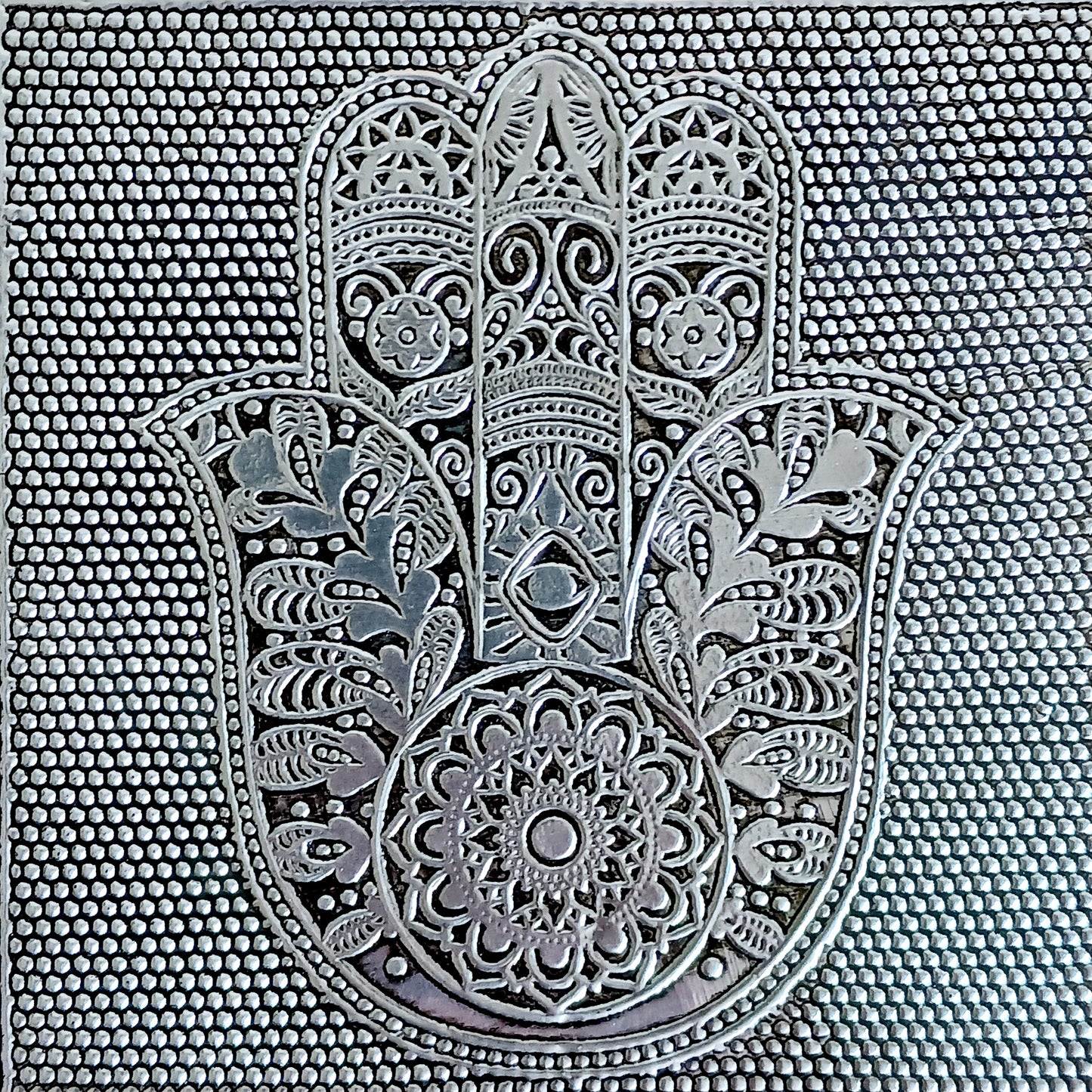 This beautiful silver colour embossed aluminium jewellery box has plenty of space for you to keep you jewellery and other valueables, and comes with a pull-out drawer.  It is lined with black cotton velvet and intricately decorated with a hamsa hand on the lid, and ornate bordering.