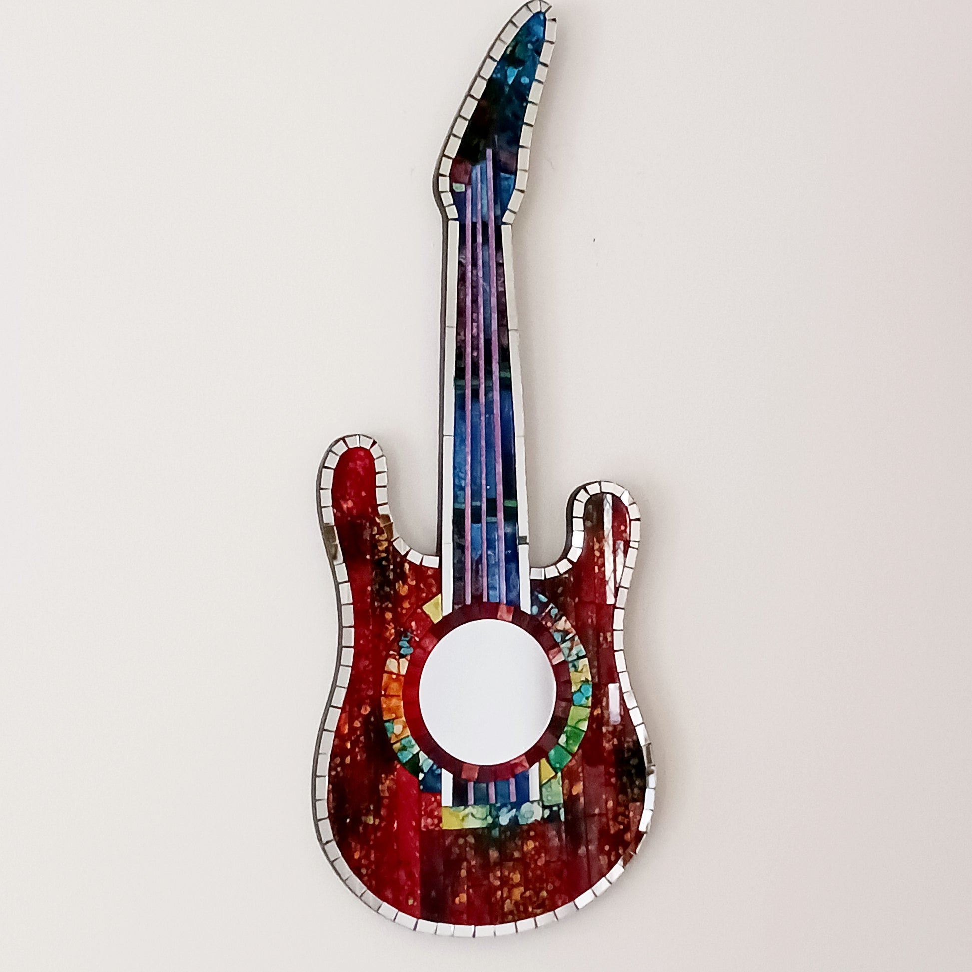 Handcrafted from shimmering, individually placed glass tiles, this stunning guitar-shaped glass mosaic mirror blends creativity, rhythm, and craftsmanship into one striking wall décor accent.