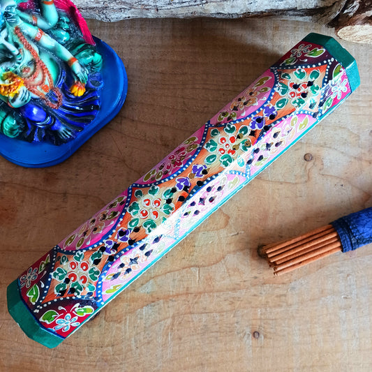 This beautiful pink and green wooden Incense box has been hand painted and has a curved hinged lid. It can accommodate both incense sticks and cones. There is also a place for you to safely store your incense sticks at the bottom on the box.