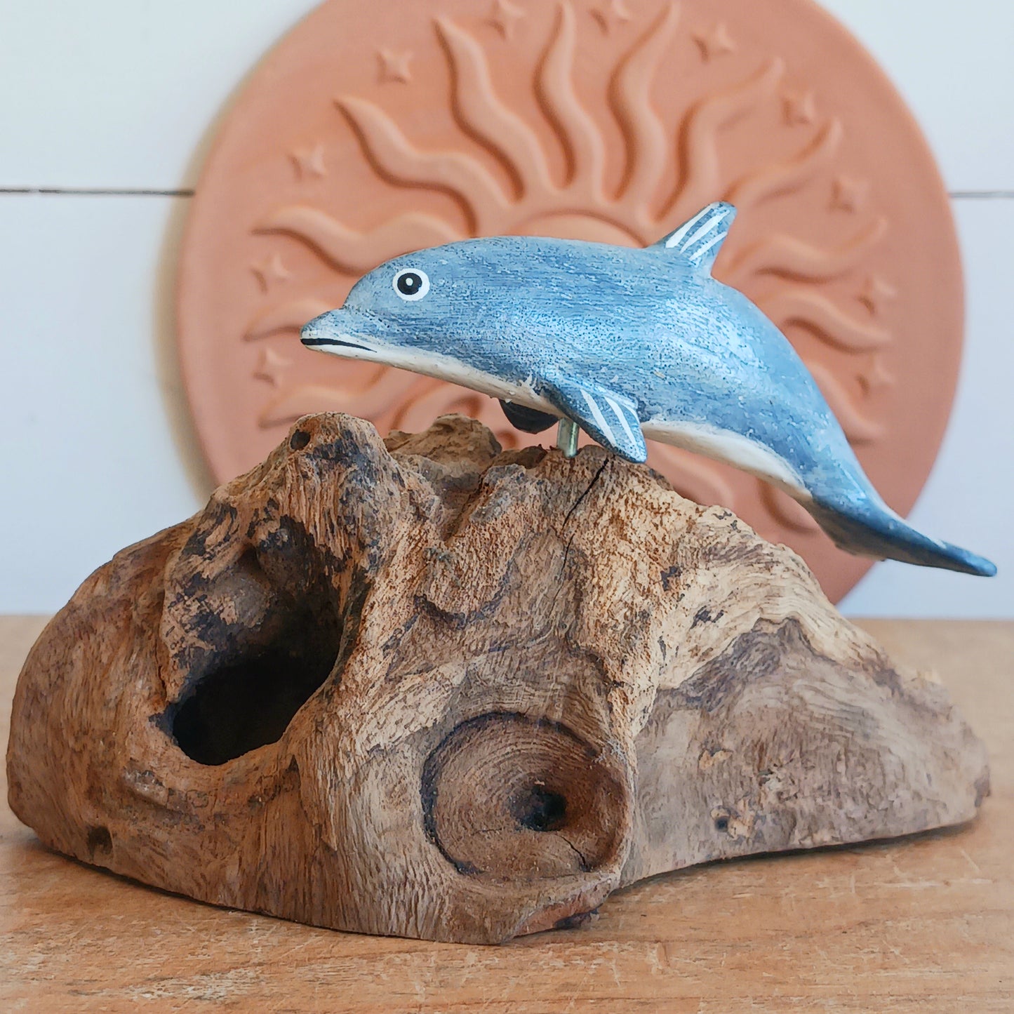 Bring the peaceful beauty of the ocean into your home with this Handcrafted Wooden Blue Dolphin Sculpture. Expertly crafted from sustainably sourced wood, this elegant decorative piece features a beautifully hand-painted blue dolphin gracefully mounted on natural driftwood, creating a striking coastal-inspired display.