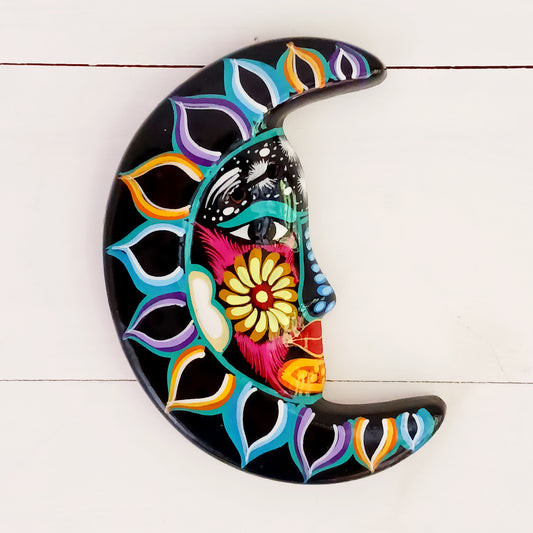 This vibrant wall plaque will have you over the moon! Expertly hand-painted in the bold, colorful style traditional to Xalitla in Guerrero, Mexico, this eye-catching piece celebrates the beauty of authentic Mexican folk art. A striking glaze enhances its vivid design, making it a stunning focal point in any room. The plaque includes two small holes for adding a hanging loop, allowing for easy wall display. Perfect for adding a splash of cultural charm to your home décor or gifting to lovers of artisan craft