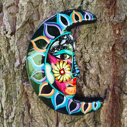 This vibrant wall plaque will have you over the moon! Expertly hand-painted in the bold, colorful style traditional to Xalitla in Guerrero, Mexico, this eye-catching piece celebrates the beauty of authentic Mexican folk art. A striking glaze enhances its vivid design, making it a stunning focal point in any room. The plaque includes two small holes for adding a hanging loop, allowing for easy wall display. Perfect for adding a splash of cultural charm to your home décor or gifting to lovers of artisan craft