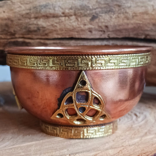 This elegant small copper bowl features a beautifully engraved brass Triquetra (Trinity Knot) design, symbolizing unity and the power of three. Perfect for spiritual rituals, altar offerings, incense burning, or as a unique decorative accent, this bowl blends sacred symbolism with timeless craftsmanship.