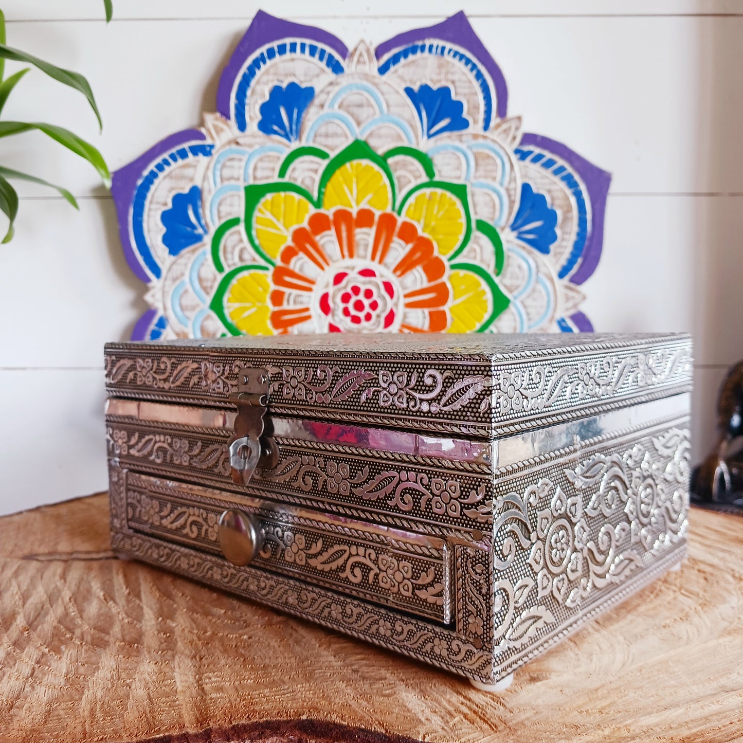 This beautiful silver colour embossed aluminium jewellery box has plenty of space for you to keep you jewellery and other valueables, and comes with a pull-out drawer.  It is lined with black cotton velvet and intricately decorated with a hamsa hand on the lid, and ornate bordering.
