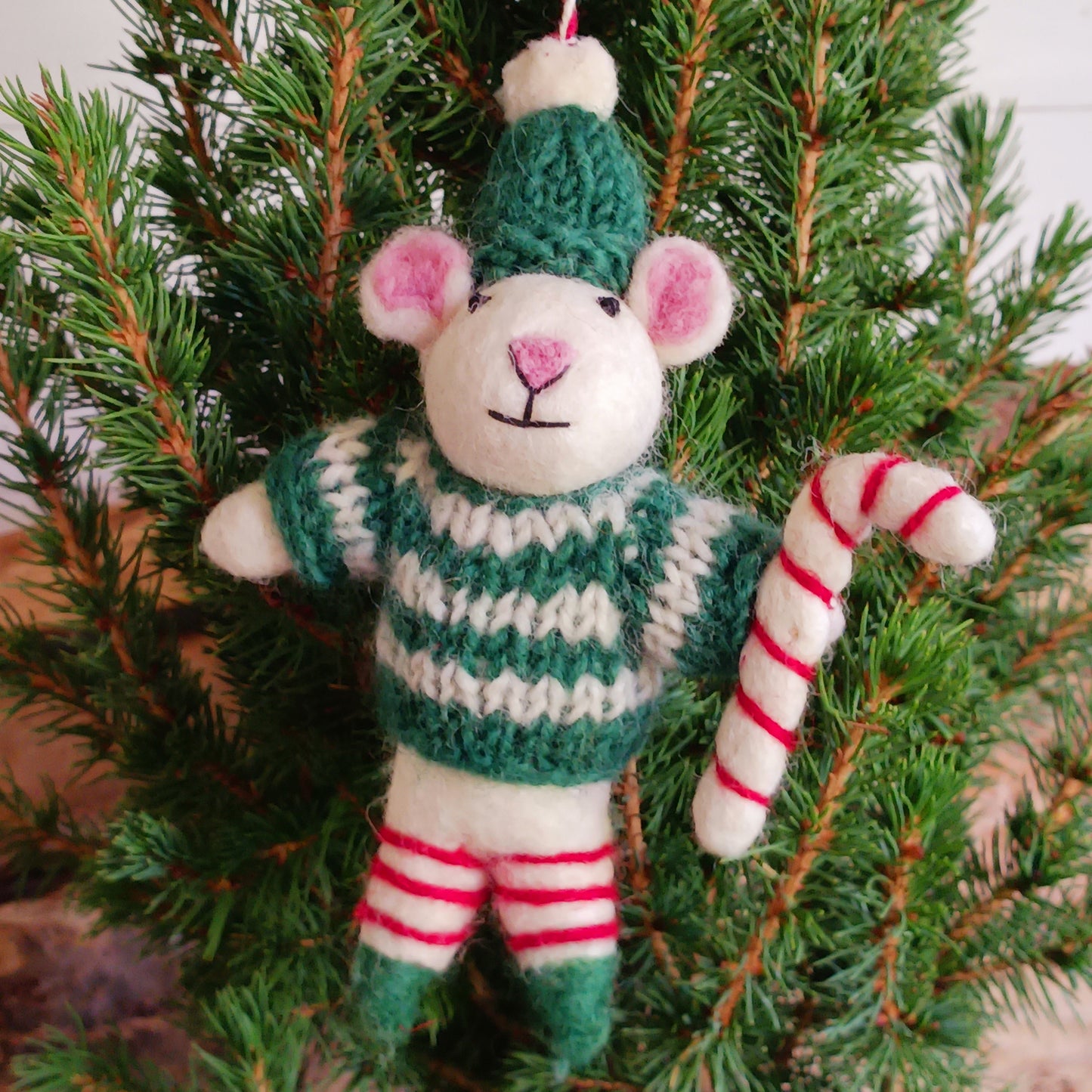 Meet our endearing little Christmas mice, dressed in vibrant elf knitwear, joyfully clutching a felt candy cane ready to spread festive cheer. Each ornament is lovingly handcrafted, capturing the magic and childlike wonder of the holiday season.