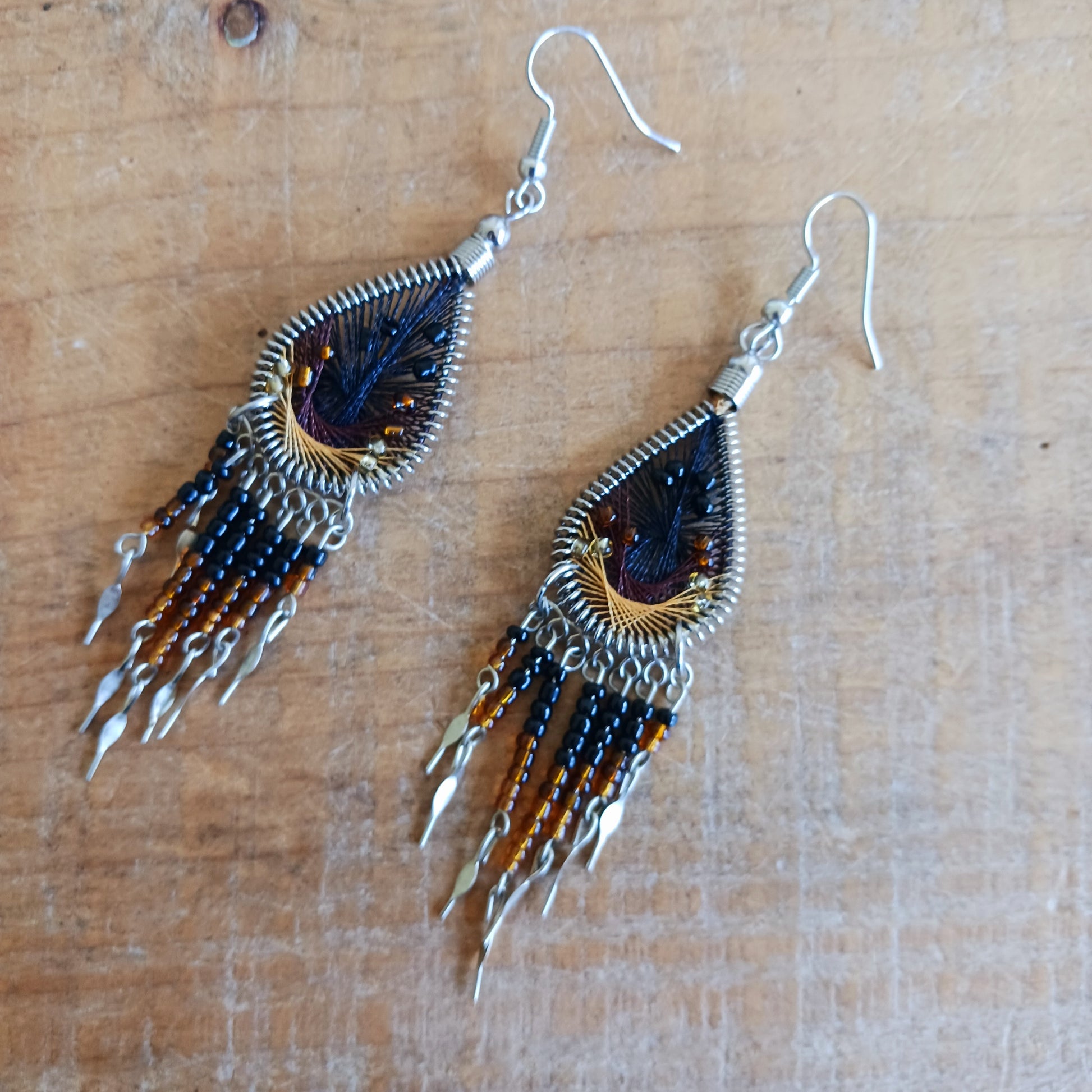 Add a splash of colour to your look with these beautiful handmade Peruvian woven teardrop earrings. Inspired by the vibrant colours and patterns of a peacock feather, each earring features intricate woven detailing complemented by coordinating beads and delicate silver-tone embellishments.