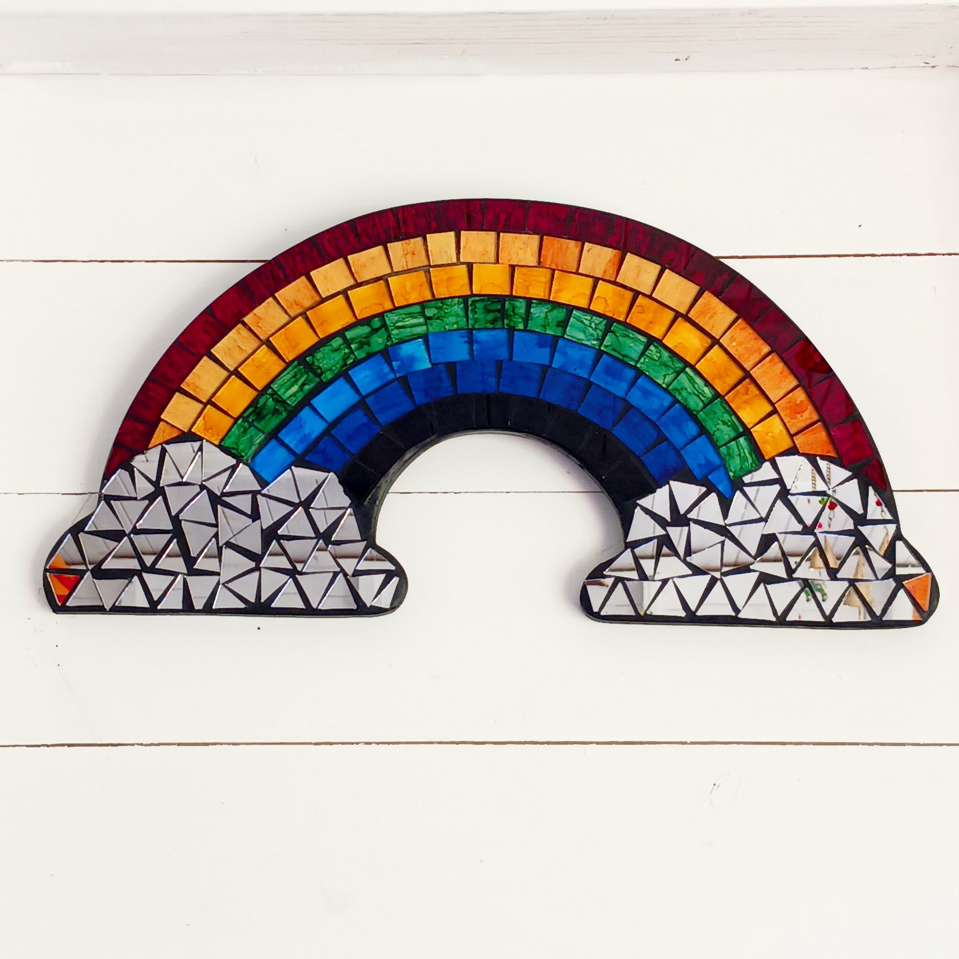Bring colour, light, and personality into your home with the Mosaic Rainbow Wall Mirror Plaque. Featuring a vibrant rainbow-inspired mosaic design with a reflective mirror centre, this decorative wall plaque adds a cheerful touch to bedrooms, nurseries, playrooms, living spaces, or hallways.