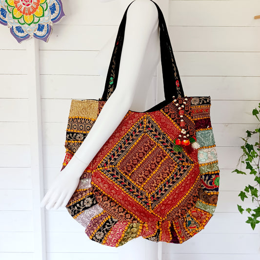 This beautiful large Indian tote bag comes with a wide shoulder strap and plenty of space inside for your personal items. In a patchwork style design, this bag is intricately embroidered with a traditional bohemian pattern.The bag comes decorated with beads and pom poms and is fully lined throughout. 