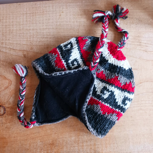 Stay cozy and stylish with our handmade chunky wool earflap hats, crafted in Nepal by skilled women artisans in Kathmandu. Each hat is 100% pure wool and features a soft polar fleece lining for extra warmth and comfort. Perfect for cold winter days, outdoor adventures, or adding a touch of handmade charm to your look.