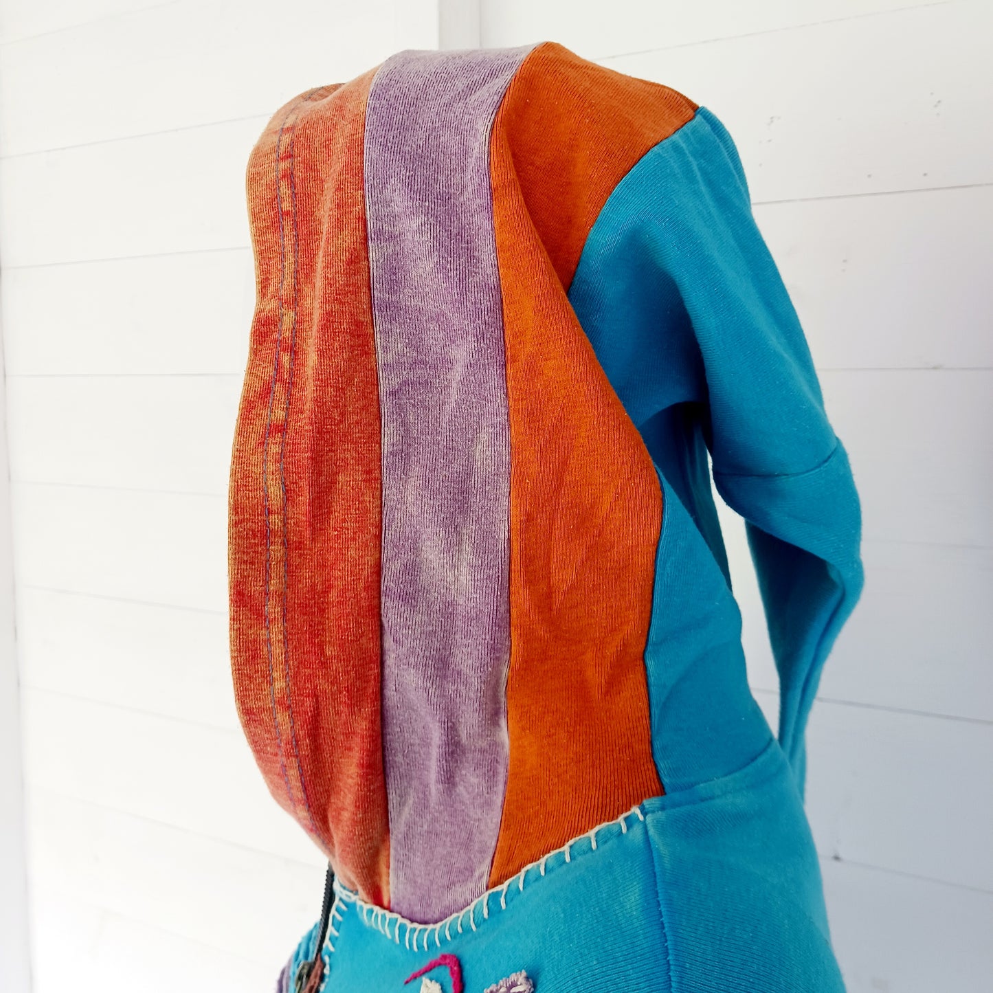Make a bold statement with this handmade turquoise Pixie Jacket, a striking patchwork coat designed for free spirits and lovers of expressive, bohemian fashion. Crafted in Nepal from soft, stretchy cotton jersey, this longline jacket blends vibrant colours, artistic prints, and intricate detailing into a truly unique outerwear piece.