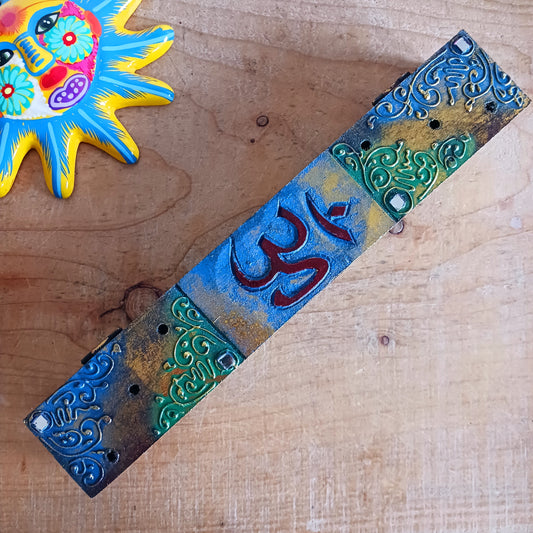 This unique incense stick holder is perfect to catch the ash from your favourite incense. It has been handmade from responsibly sourced wood, skilfully carved and beautifully decorated with a centre OM symbol.