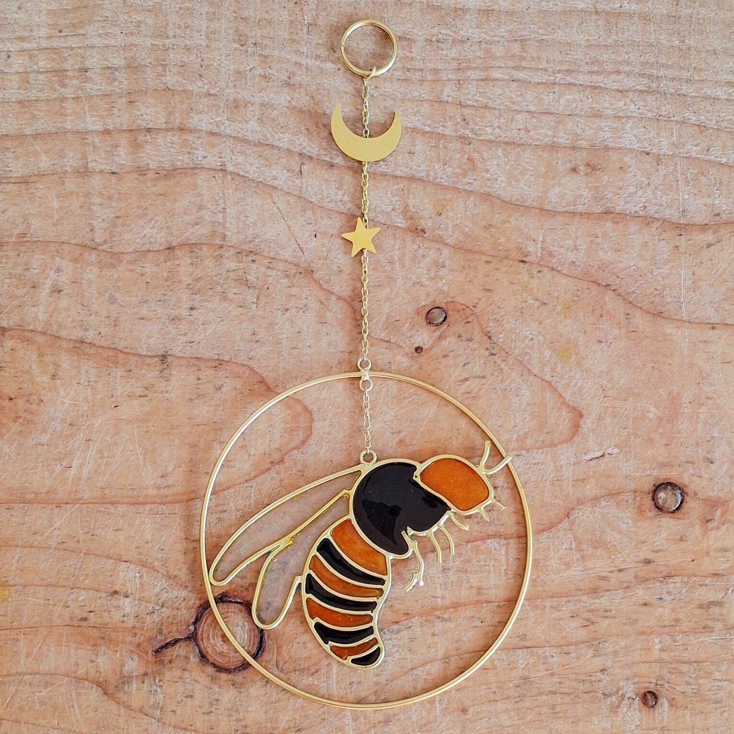 Add a touch of sunshine to the home with this summer bee suncatcher. This charming suncatcher features a beautifully detailed bee, star and crescent moon design made from metal and resin. Hang it in the window to catch the light and bring a cheerful, colourful glow to any room.