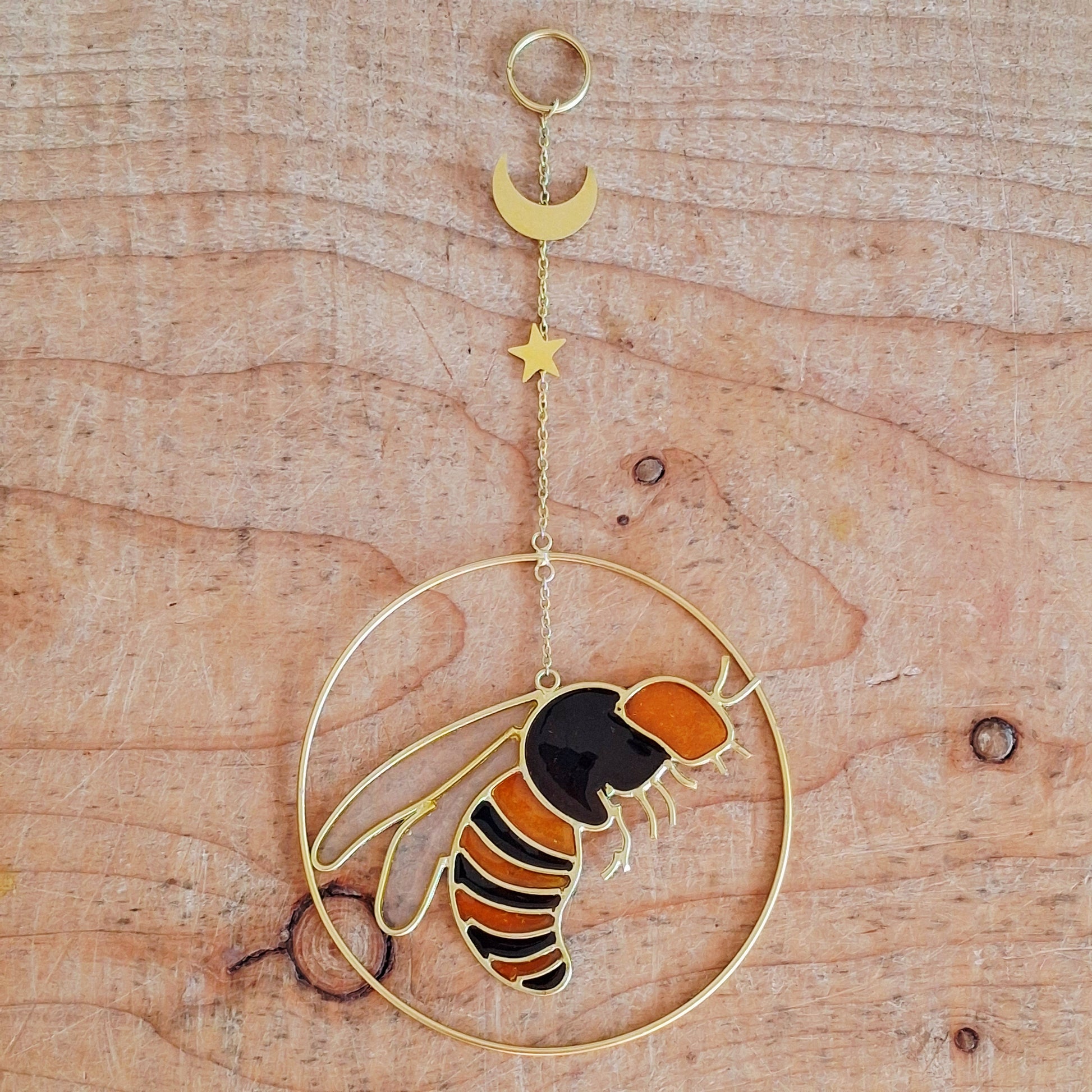 Add a touch of sunshine to the home with this summer bee suncatcher. This charming suncatcher features a beautifully detailed bee, star and crescent moon design made from metal and resin. Hang it in the window to catch the light and bring a cheerful, colourful glow to any room.