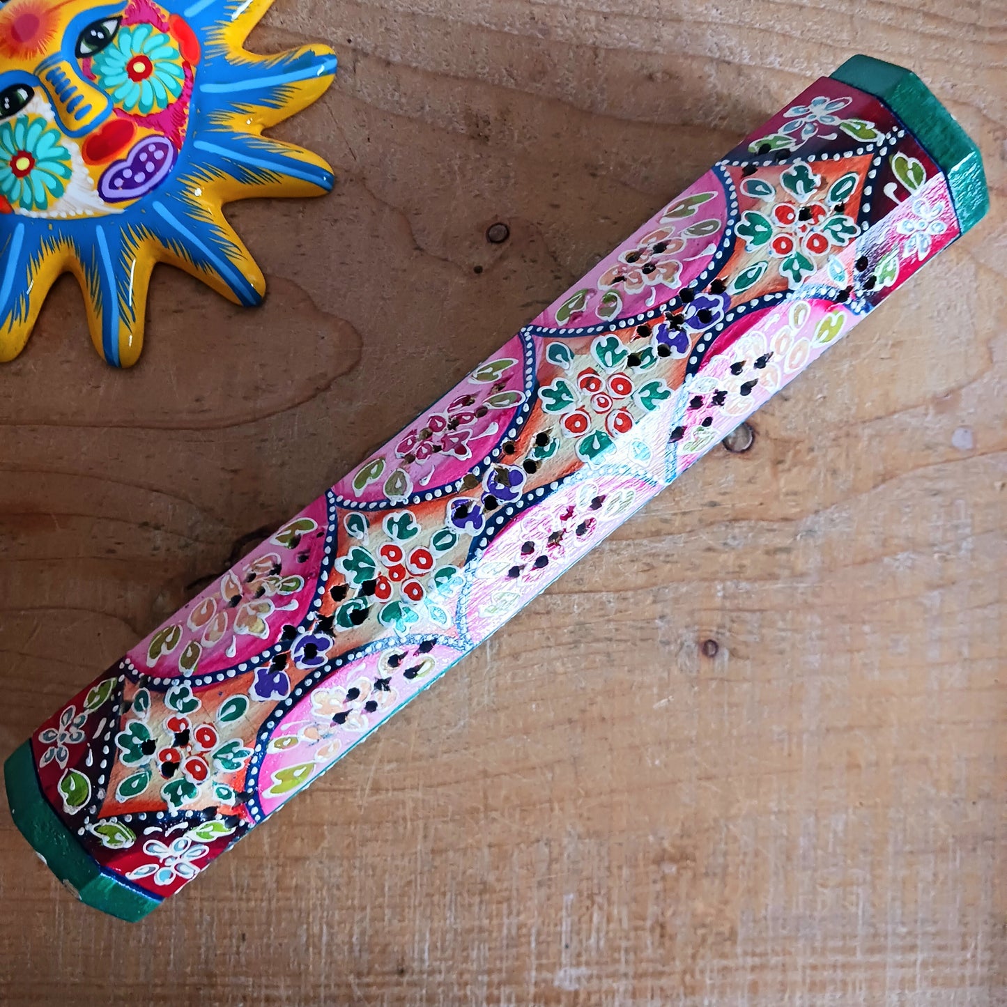 This beautiful pink and green wooden Incense box has been hand painted and has a curved hinged lid. It can accommodate both incense sticks and cones. There is also a place for you to safely store your incense sticks at the bottom on the box.