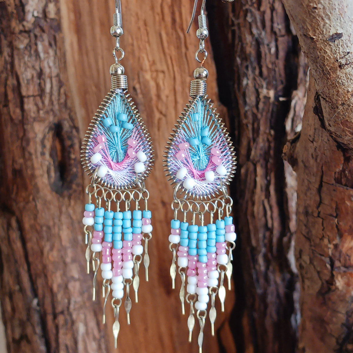 Add a splash of colour to your look with these beautiful handmade Peruvian woven teardrop earrings. Inspired by the vibrant colours and patterns of a peacock feather, each earring features intricate woven detailing complemented by coordinating beads and delicate silver-tone embellishments.