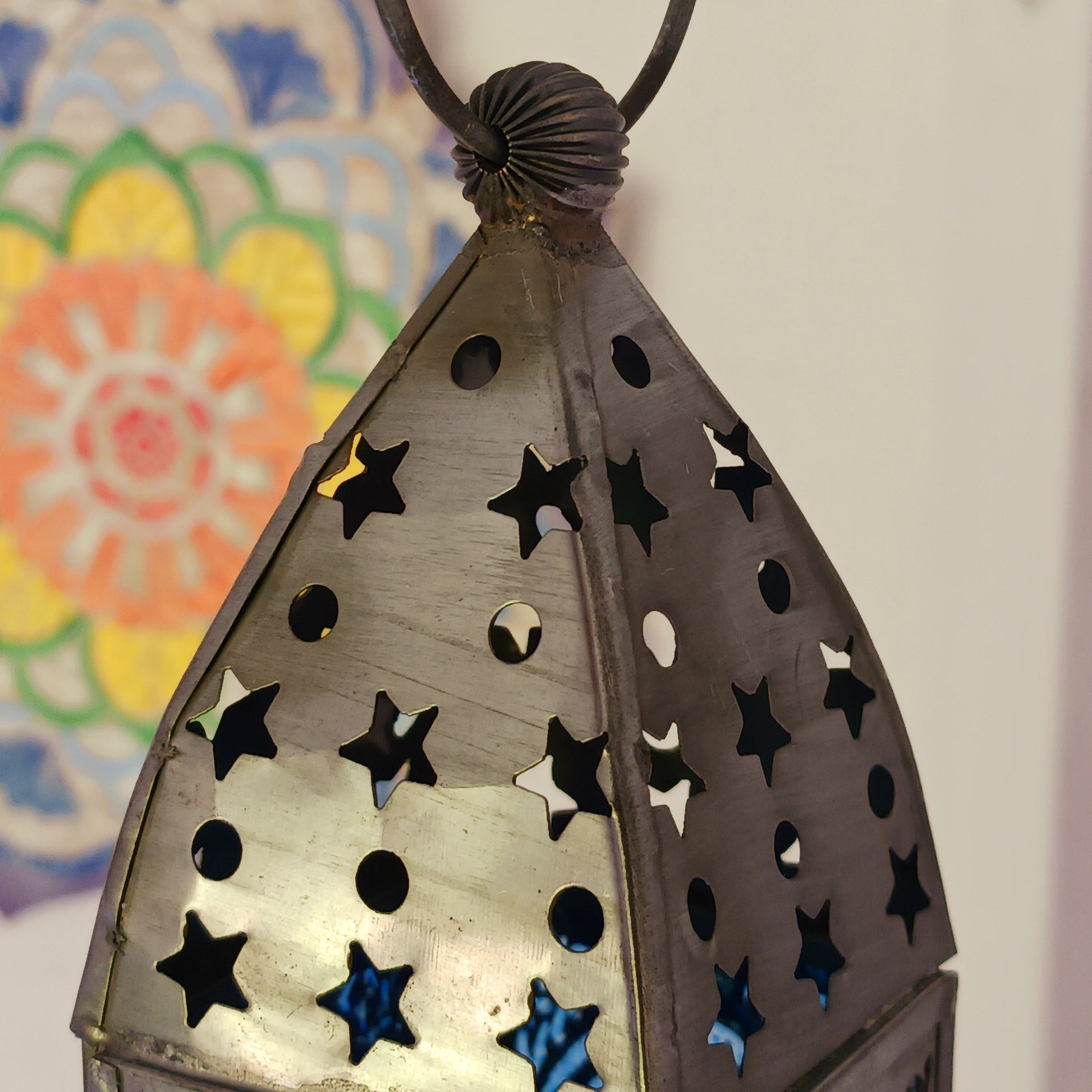 Bring warmth, colour and spiritual harmony to your home with this beautiful Pentagram Glass Lantern. Designed with vibrant coloured glass panels and a decorative metal cut-out canopy, this lantern creates a calming glow that enhances meditation spaces, yoga rooms and home décor.