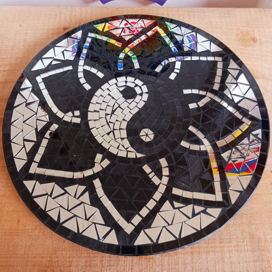 Bring balance, energy, and harmony to your space with this large handcrafted Mosaic Yin and Yang Wall Plaque. Each plaque is carefully created using small glass pieces, meticulously arranged to form a striking black and silver yin and yang design. The reflective mosaic catches the light beautifully, adding depth and elegance to any room. 