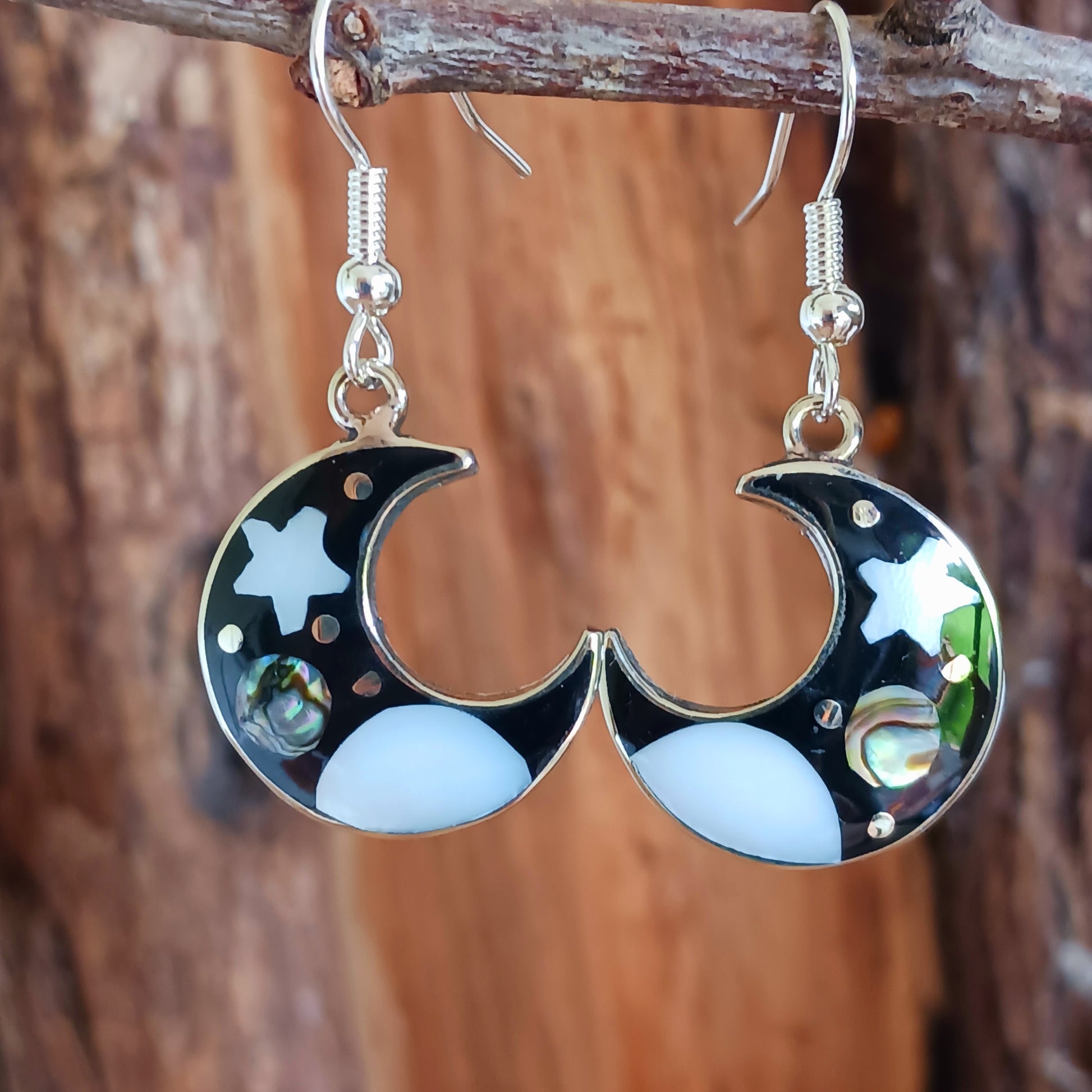 This set of beautiful celestial themed earrings are hand crafted in Taxco, Mexico. Utilising a eye-catching crescent moon design created using traditional Alpaca steel as the frame. These earrings have a celestial theme created using dyed, iridescent abalone shell.