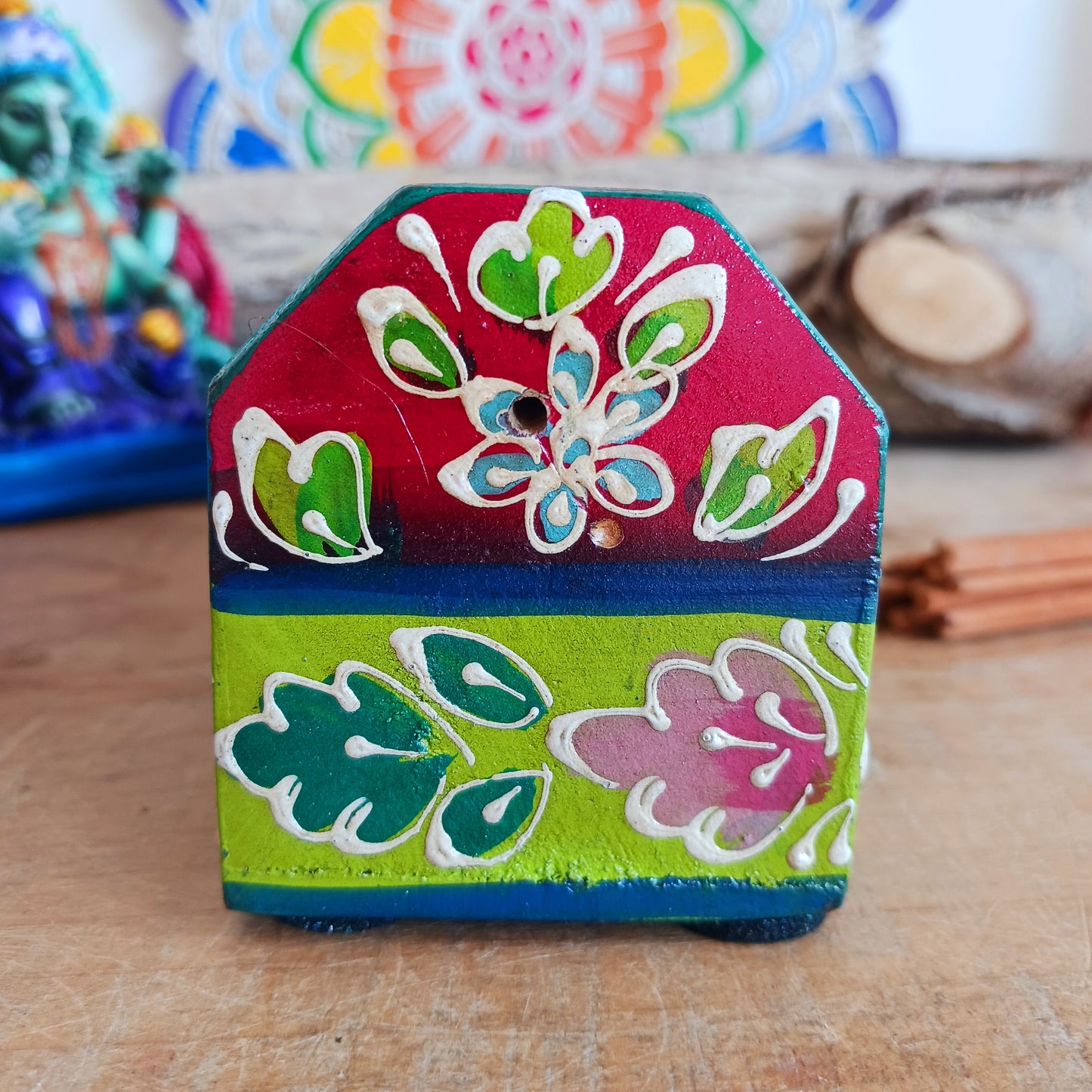 This beautiful pink and green wooden Incense box has been hand painted and has a curved hinged lid. It can accommodate both incense sticks and cones. There is also a place for you to safely store your incense sticks at the bottom on the box.