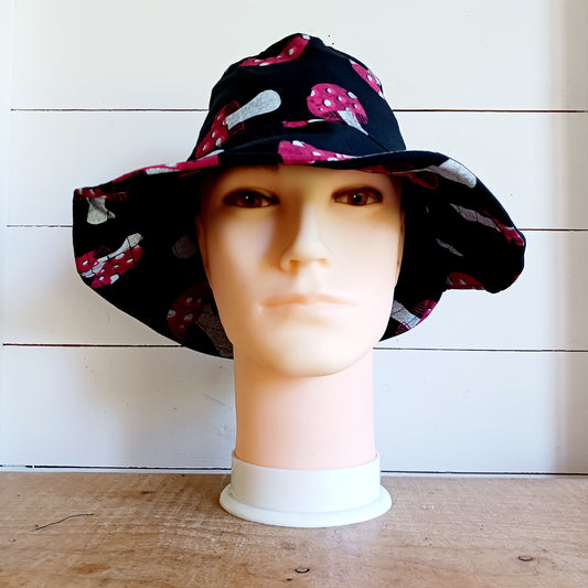 Stand out from the crowd with this lightweight Festival Mushroom Print Bucket Hat. Designed for festival season, holidays, beach days, and everyday summer wear, this stylish bucket hat features a bold all-over mushroom print that adds a fun, eye-catching touch to any outfit.