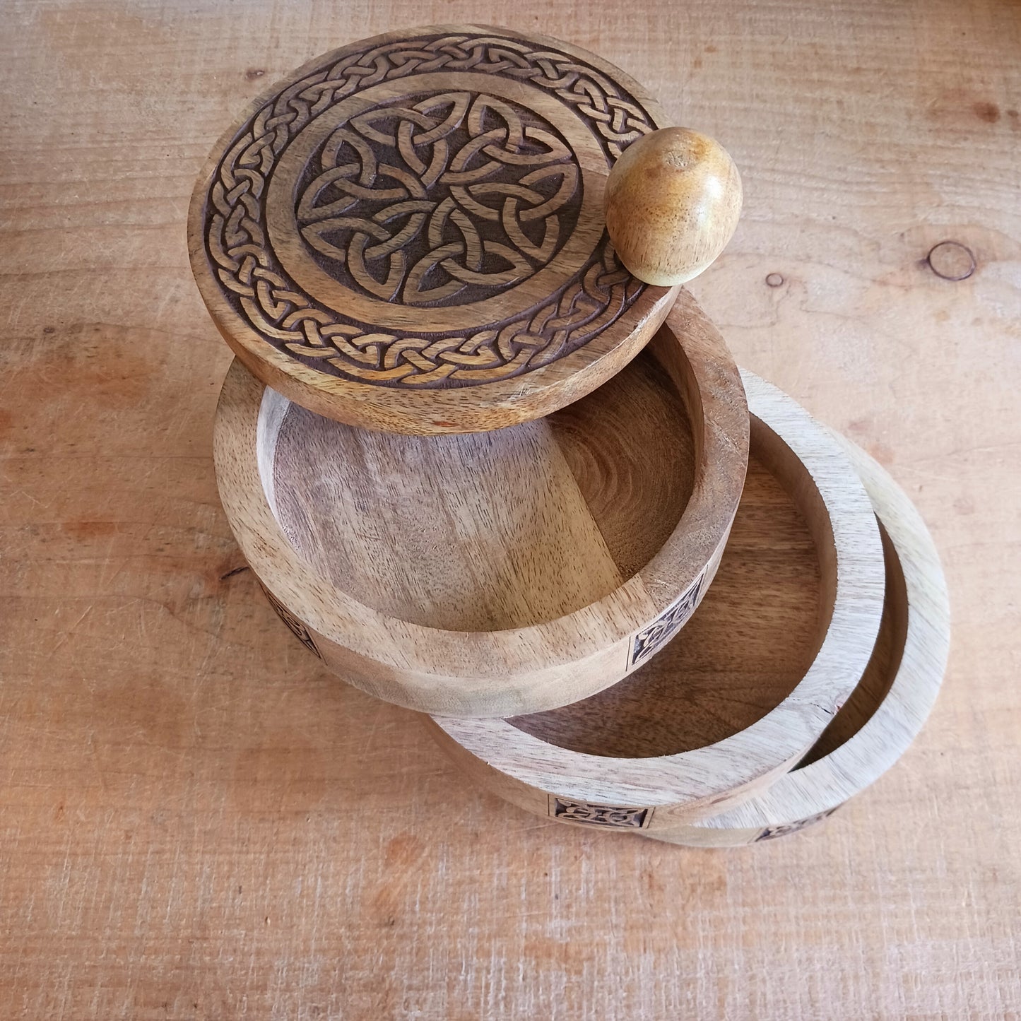 Bring timeless craftsmanship and functional beauty into your space with this Celtic Carved Revolving Storage Box, expertly hand-crafted from sustainable mango wood. Designed with both elegance and practicality in mind, this unique 3-tier swivel box opens smoothly from a central pivot, revealing three spacious compartments that fan out effortlessly.