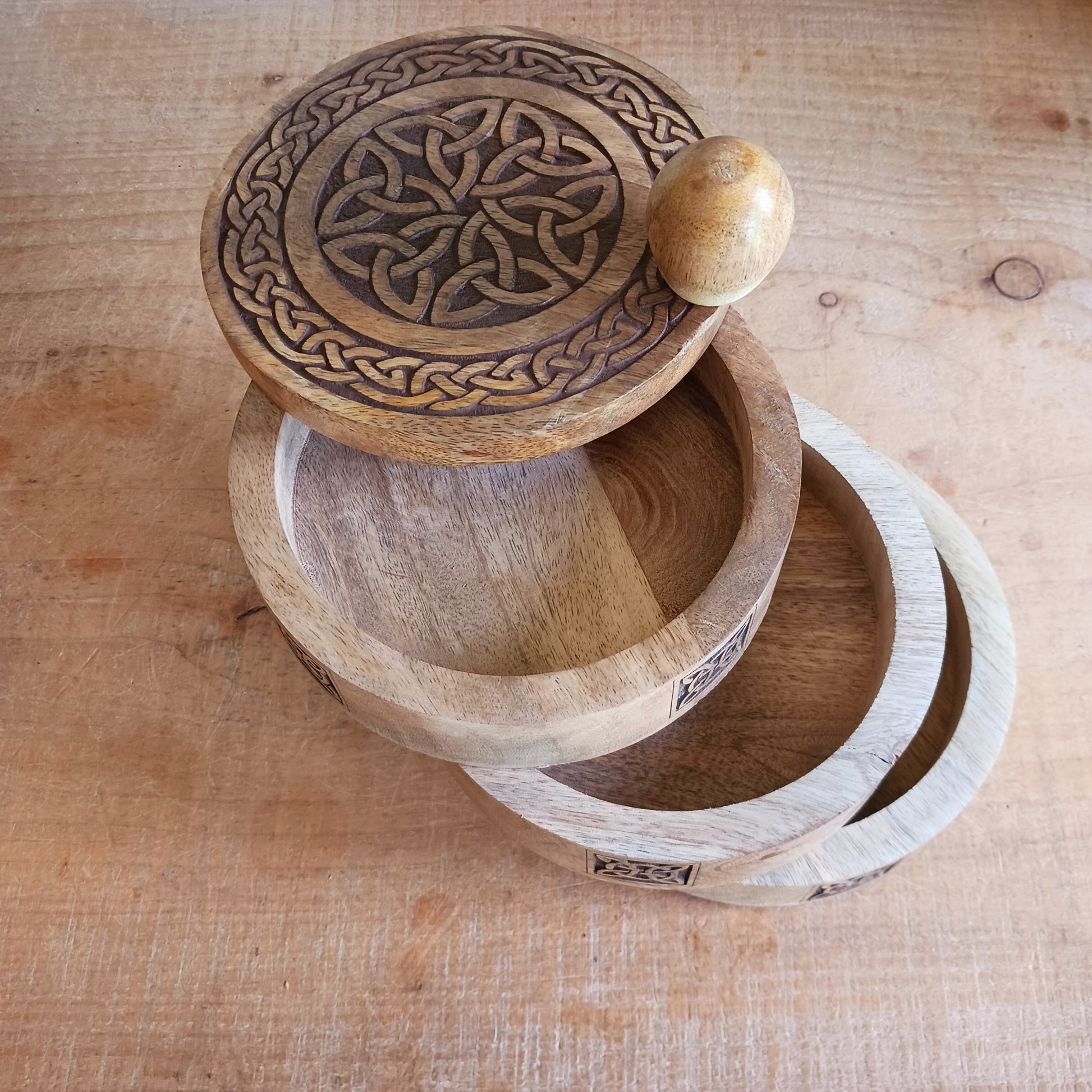 Bring timeless craftsmanship and functional beauty into your space with this Celtic Carved Revolving Storage Box, expertly hand-crafted from sustainable mango wood. Designed with both elegance and practicality in mind, this unique 3-tier swivel box opens smoothly from a central pivot, revealing three spacious compartments that fan out effortlessly.
