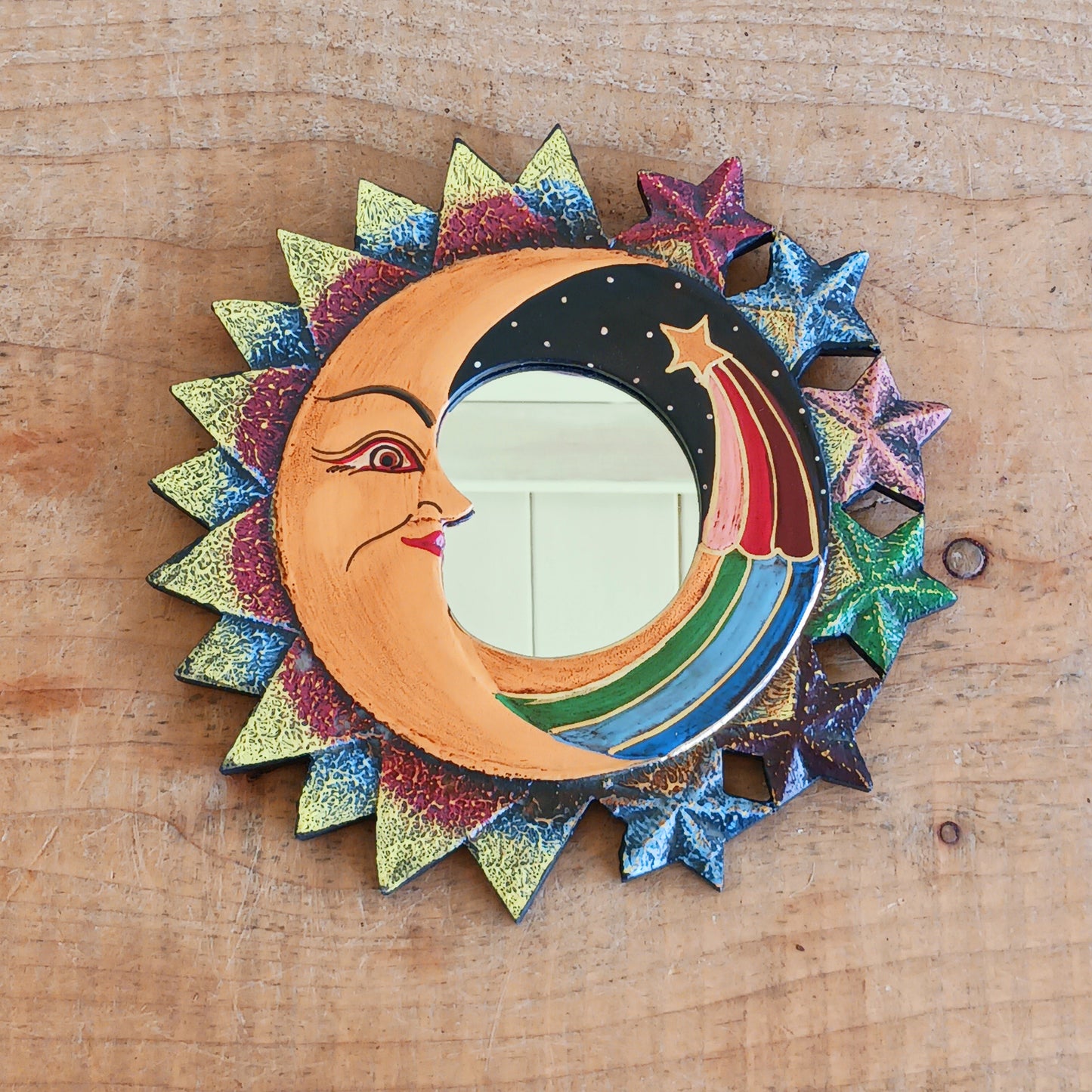 Bring celestial charm and positive energy into your home with this little Handmade Moon &amp; Stars Mirror. Carefully crafted by Fair Trade artisans, this unique decorative mirror features a stunning purple crescent moon design that adds a mystical and spiritual touch to any room.