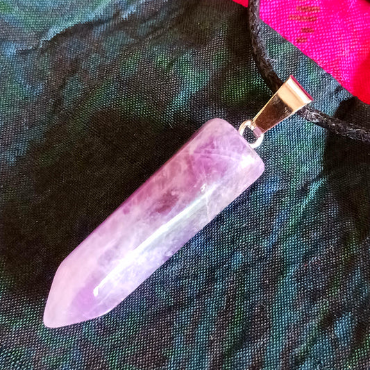 Elevate your style and energy with this stunning Amethyst Crystal Pendant Necklace. Featuring a natural amethyst crystal on a sleek black cord, this piece is both a beautiful accessory and a powerful spiritual tool. Amethyst, known as the stone of spirituality and peace, ranges in shades from soft lavender to deep violet.
