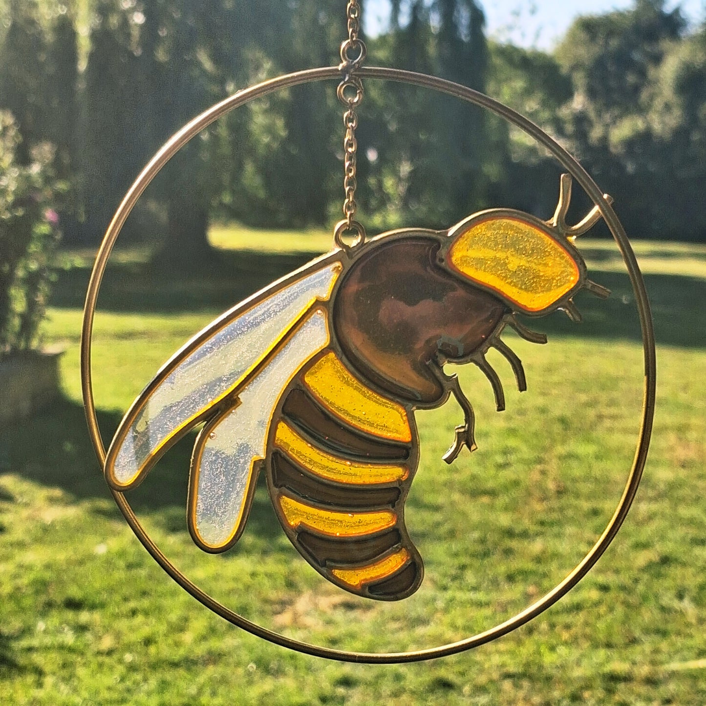 Add a touch of sunshine to the home with this summer bee suncatcher. This charming suncatcher features a beautifully detailed bee, star and crescent moon design made from metal and resin. Hang it in the window to catch the light and bring a cheerful, colourful glow to any room.